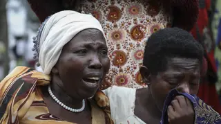 Relatives grieve as they wait to collect the bodies of villagers who were killed in the attack