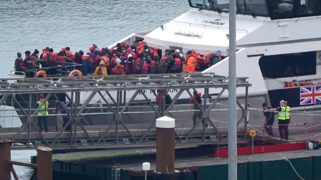A crowd of Channel migrants are pictured on a Border Force vessel after being picked up on the perilous waters