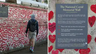 A member of the public walks past the Covid memorial wall