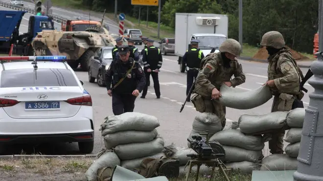Russian officials are pictured placing sandbags and sentry guns on the outskirts of Moscow