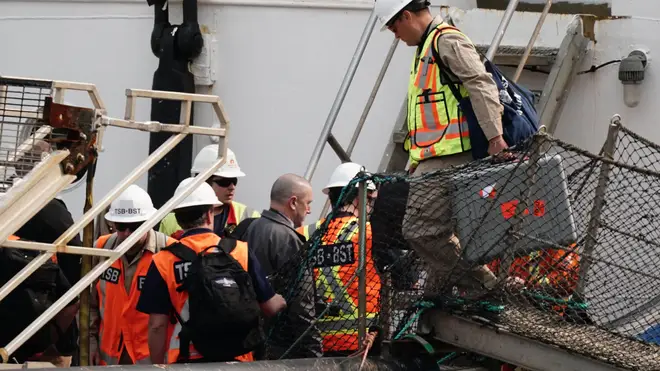 Investigators are pictured boarding the support vessel after it arrived at harbour in Newfoundland on Saturday