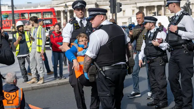 A Just Stop Oil protester is dragged away by police officers at Trafalgar Square