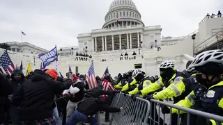 Rioters supporting then president Donald Trump try to break through a police barrier at the Capitol in Washington, on January 6 2021 (Julio Cortez/AP)