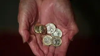 An elderly woman holding coins