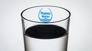 The Thames Water logo seen through a glass of water