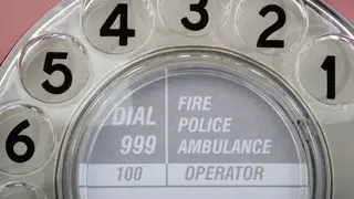 An old fashioned phone with a reminder for 999