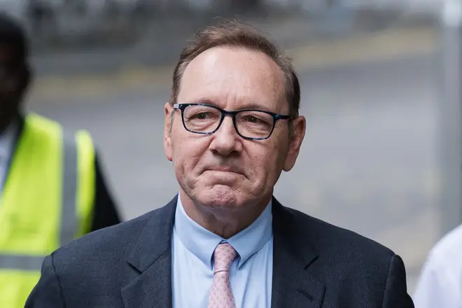 Kevin Spacey smiles as he arrives at Southwark Crown Court