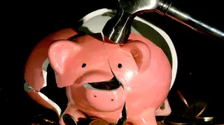 A piggy bank being smashed with a hammer