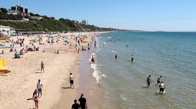 British beach with people enjoying the water and sand during a heatwave