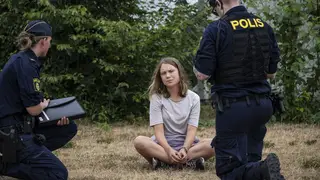 Police officers talk to Swedish climate activist Greta Thunberg as they move activists from the organisation Ta Tillbaka Framtiden (Take Back The Future) blocking the entrance to the Oljehamnen neighb