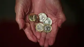 Woman holding pound coins in her hands