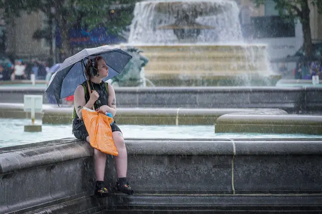 Tourists and locals take cover during a heavy rain burst on Saturday afternoon in London