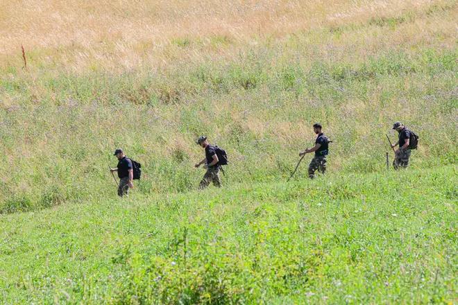 Police meticulously search the outskirts of the village of Vernet