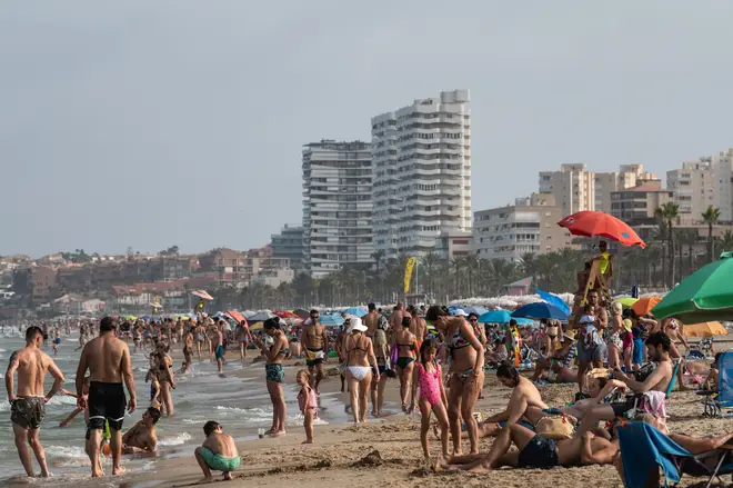 Tourists and locals enjoy a hot summer day at San Juan Beach in Alicante