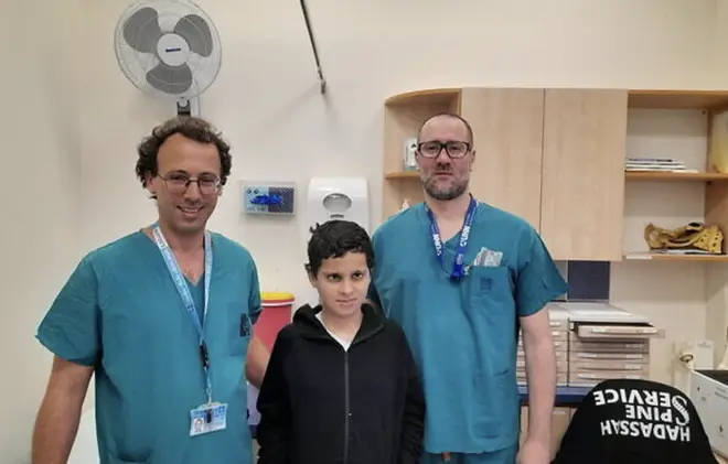 El Dr. Ohad Einav y Ziv Asa con Suleiman Hassan, de 12 años, en el Centro Médico Hadassah después de que le volvieran a colocar la cabeza.