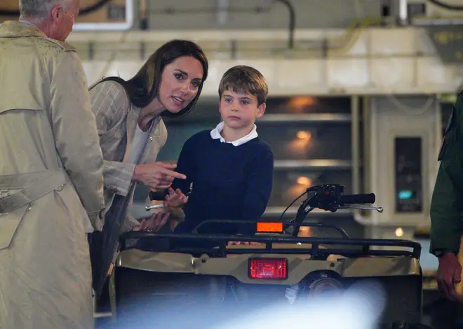 Prince Louis prepares to greet the camera as Kate looks on