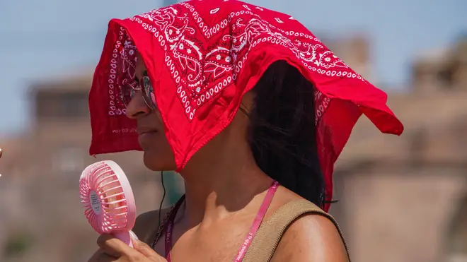 A woman covers her head from the soaring heat