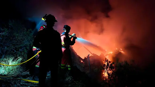 Military Emergency Unit personnel work to extinguish a forest fire the Canary island of La Palma, Spain