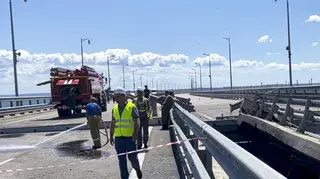 Employees work at the damaged parts the Crimean Bridge connecting the Russian mainland and Crimean peninsula over the Kerch Strait