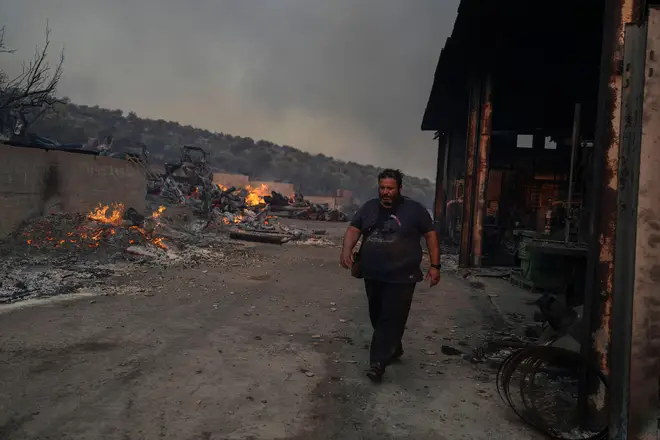 Thanassis Barberakis walks at his family shipyard damaged from the fire in Mandra, west of Athens