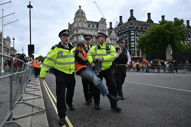 A Just Stop Oil climate activist is carried by police after being detained as members of the group marched slowly in Parliament Square ahead of a press conference