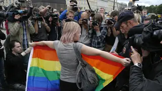 A gay rights activist stands with a rainbow flag during a protest in St Petersburg, Russia