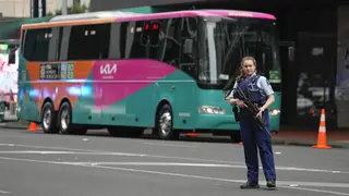Armed New Zealand police officers stand outside a hotel housing a team from the Women’s World Cup in the central business district following a shooting in Auckland