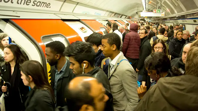 A busy London Underground platform packed with people as they try and get on a tube