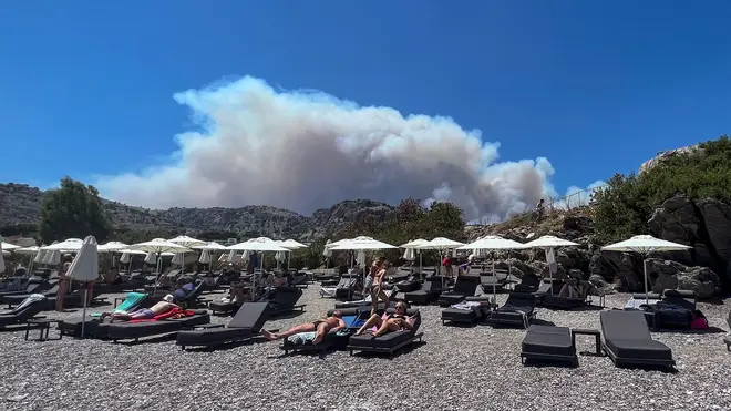 Smoke from wildfires looms over the holiday island of Rhodes