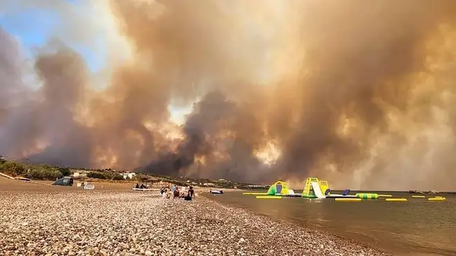 Clouds of smoke from a forest fire rise to the sky on the island of Rhodes
