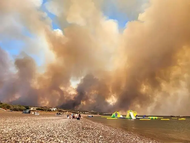 Clouds of smoke from a forest fire rise to the sky on the island of Rhodes
