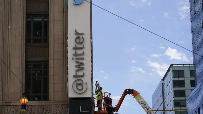 A workman removes a character from a sign on the Twitter headquarters building in San Francisco