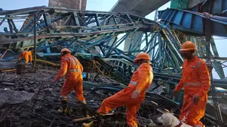 Rescuers in orange suits among wreckage