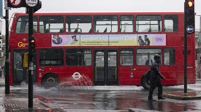 London bus splashing through puddles after heavy rainfall