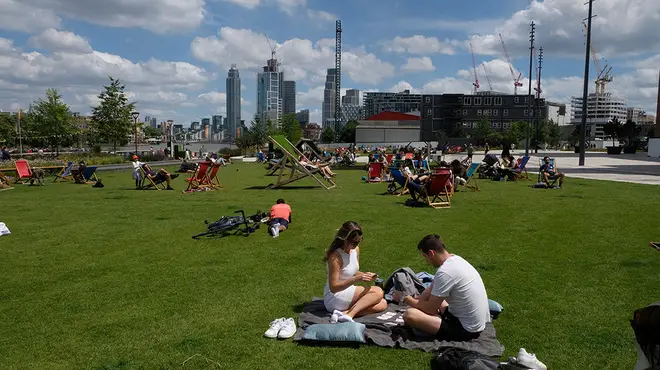 People sitting in a park in the summer sunshine in London