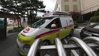 An ambulance leaves Songchon High School in Daejeon, South Korea