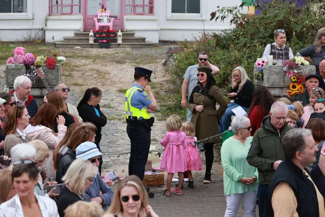 A Garda officer talking to people outside the former home of the late singer in Bray, Co Wicklow, ahead of the funeral today. Picture date: Tuesday August 8, 2023.