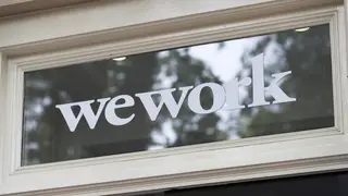 Signage outside the co-working office space group, WeWork, at Soho Square in London