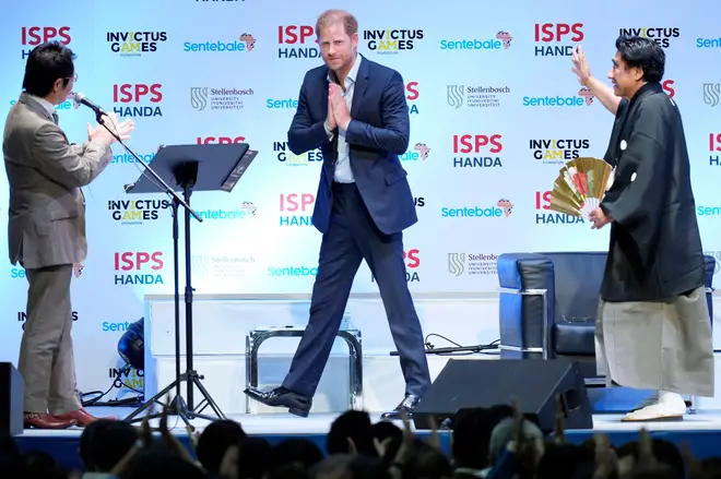Britain's Prince Harry gestures as Haruhisa Handa, right, CEO of the International Sports Promotion Society (ISPS)