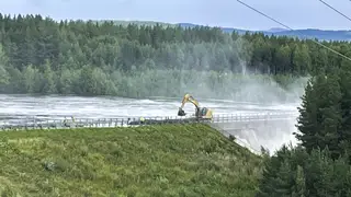 Workers reinforce a dam at risk of bursting