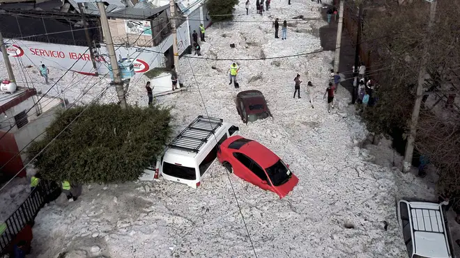 Vehicles buried in hail are seen in the streets of Guadalajara