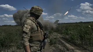 A Ukrainian soldier watches a Grad multiple launch rocket system firing shells near Bakhmut