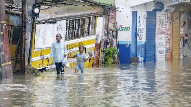 People walk through a flooded street in Santo Domingo, Dominican Republic