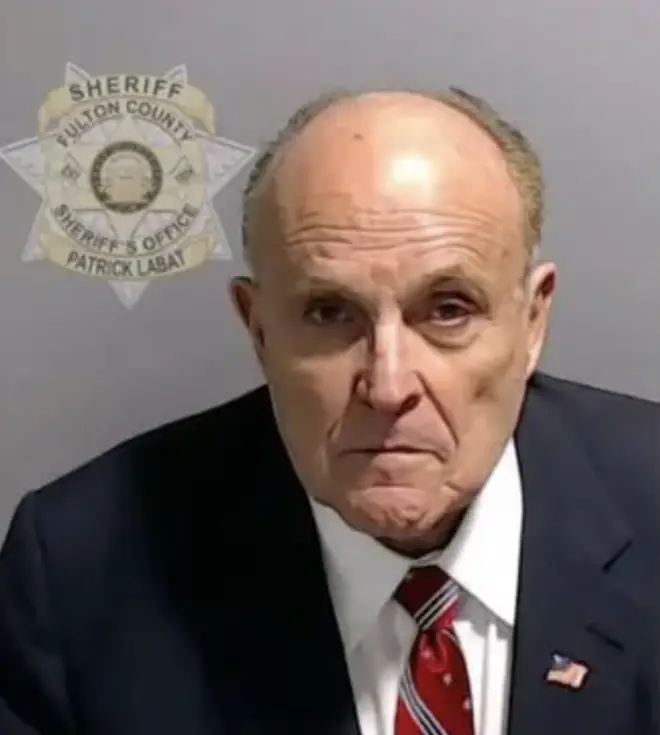 Rudy Giuliani hands himself in to police