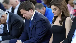 Ron DeSantis, centre, and his wife Casey bow their heads during a prayer at a vigil for the victims of Saturday’s mass shooting