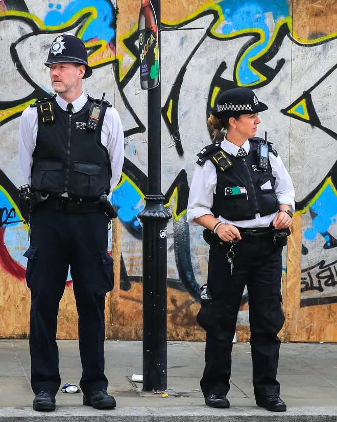 Metropolitan police officers watch the crowds at the Notting Hill Carnival