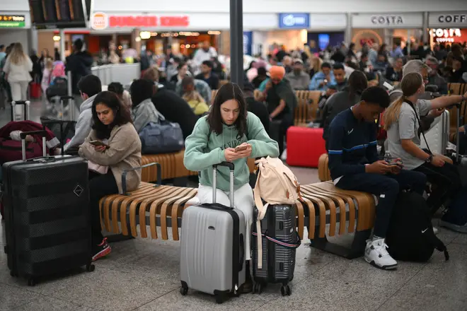 Passengers wait at Stansted Airport, north of London, on August 29, 2023 after UK flights were delayed over a technical issue