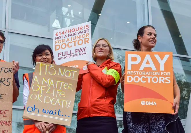 Doctors hold placards in support of fair pay at the British Medical Association (BMA) picket