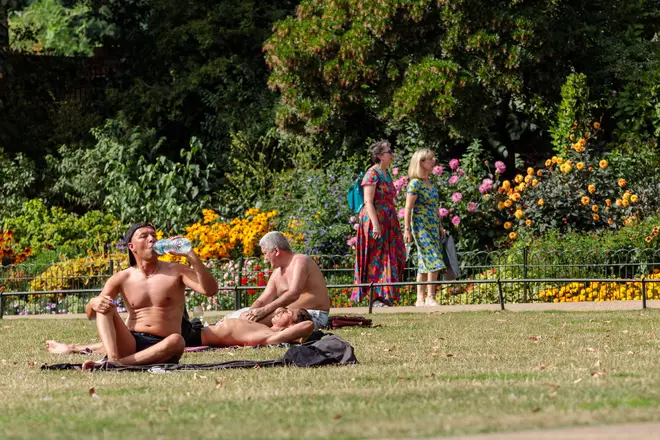 People make the most of the late summer sun in a park in London's Westminster
