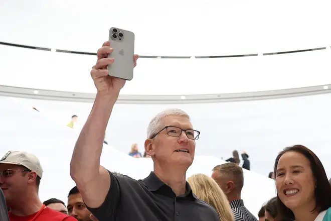 Apple CEO Tim Cook holds up a new iPhone 15